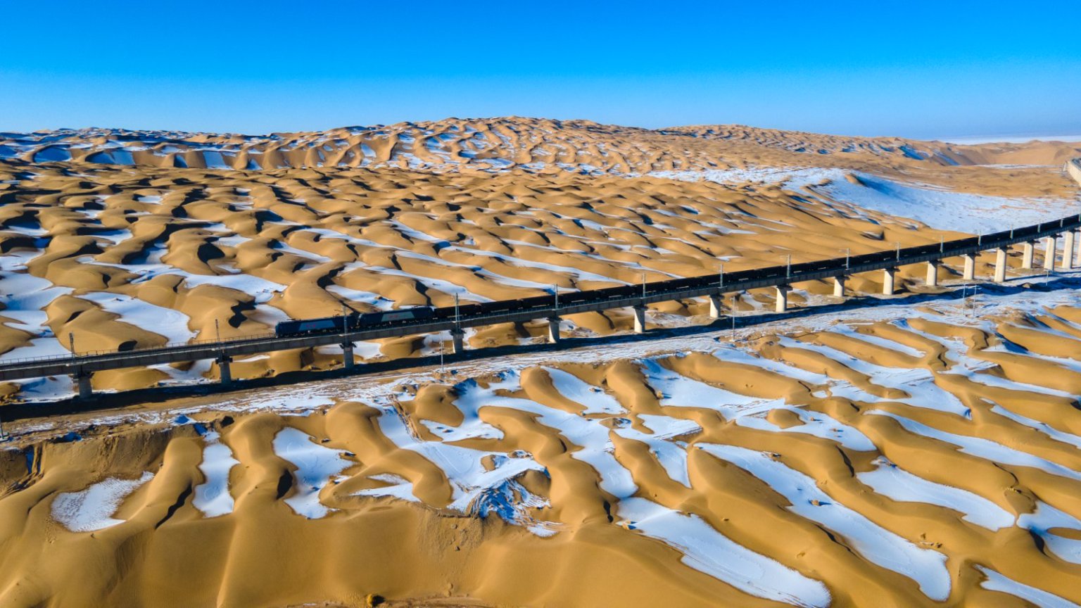 火車穿越雪后大漠。徐凌波攝