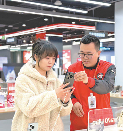 消費者(左)在湖北武漢一家商場里挑選手機。人民日報記者 吳君攝