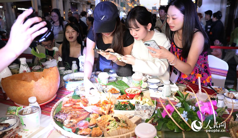 游客拍照打卡體驗(yàn)長桌宴。人民網(wǎng)記者 符武平攝