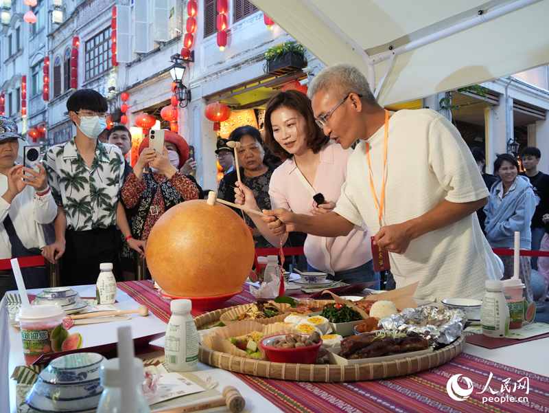 嘉賓品嘗海南傳統(tǒng)美食“煎堆”。人民網(wǎng)記者 張力洋攝
