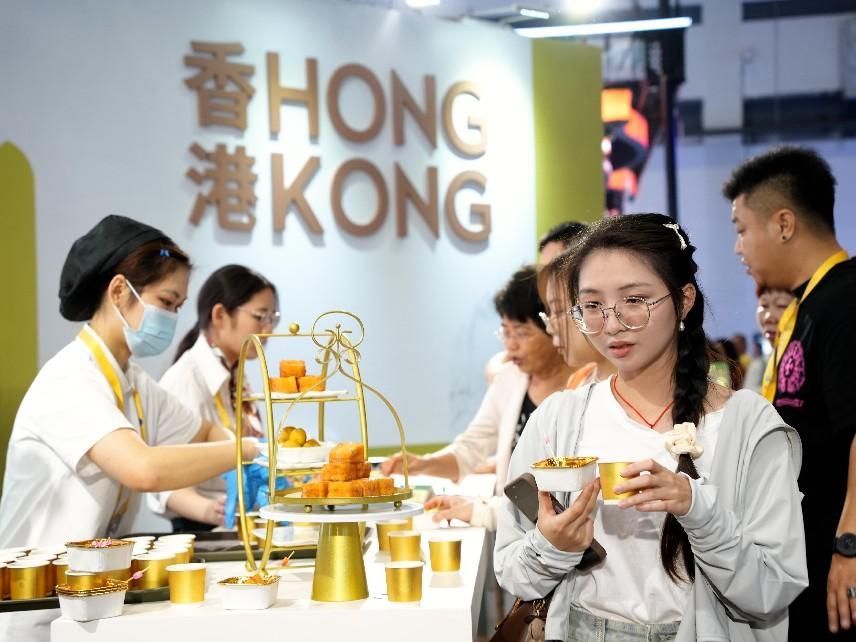 消博會現(xiàn)場，參觀者在展臺嘗試糕點美食。人民網記者 張力洋攝