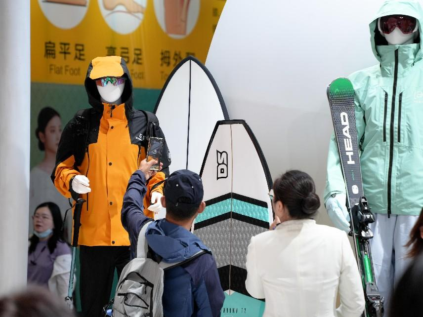 參觀者在展臺(tái)拍攝戶外潮服新品。人民網(wǎng)記者 張力洋攝