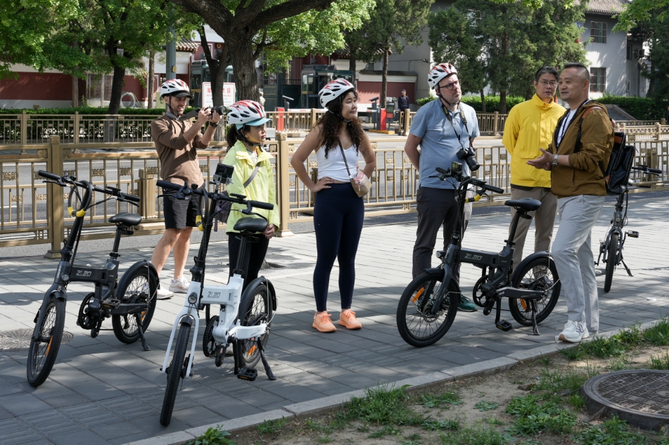騎行游覽北京中軸線的間隙，竇俊杰為游客講解。受訪者供圖