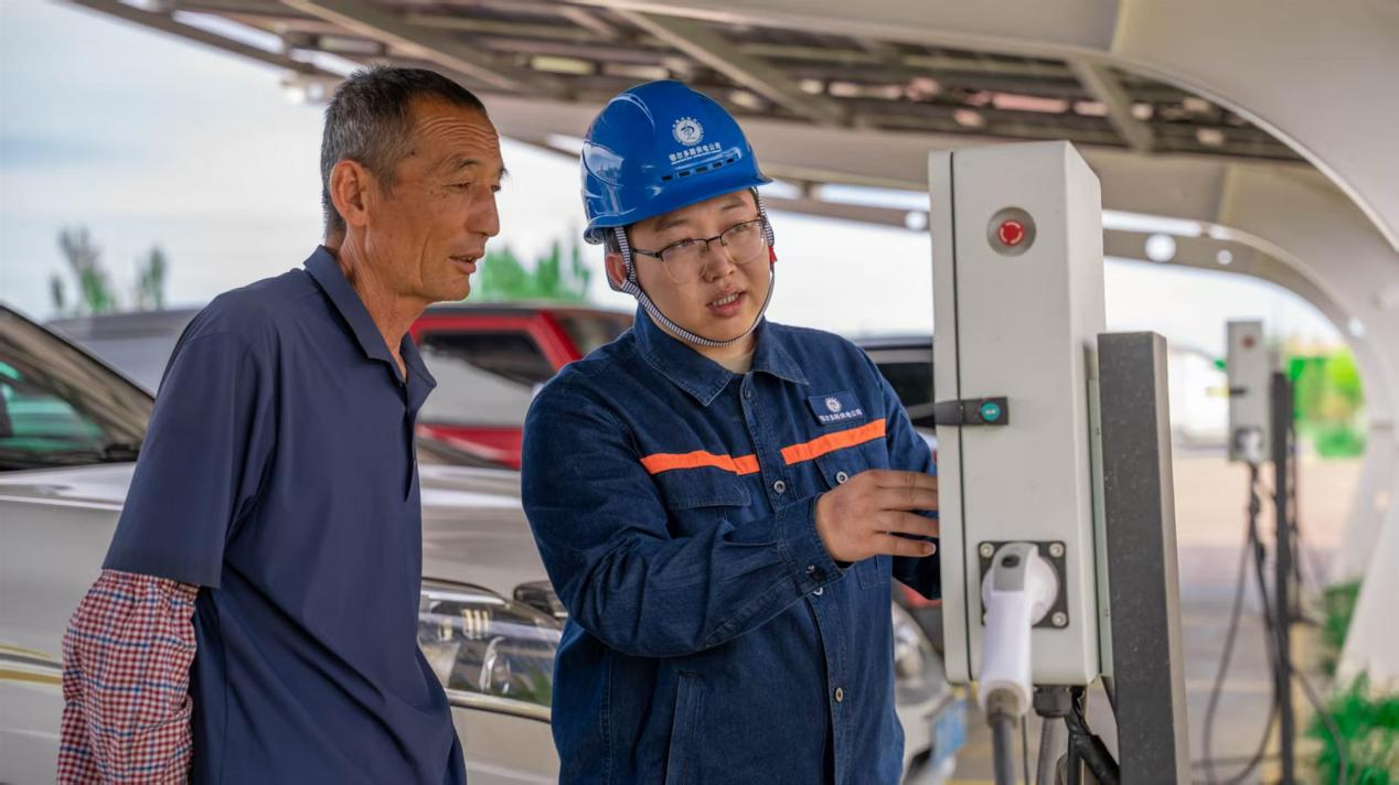 供電公司工作人員與村民交流充電事項(xiàng)。受訪者供圖