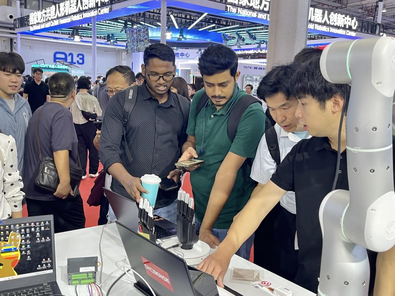 大會(huì)現(xiàn)場，中外友人紛紛駐足，俯身細(xì)觀展品。人民網(wǎng)記者 王天樂攝