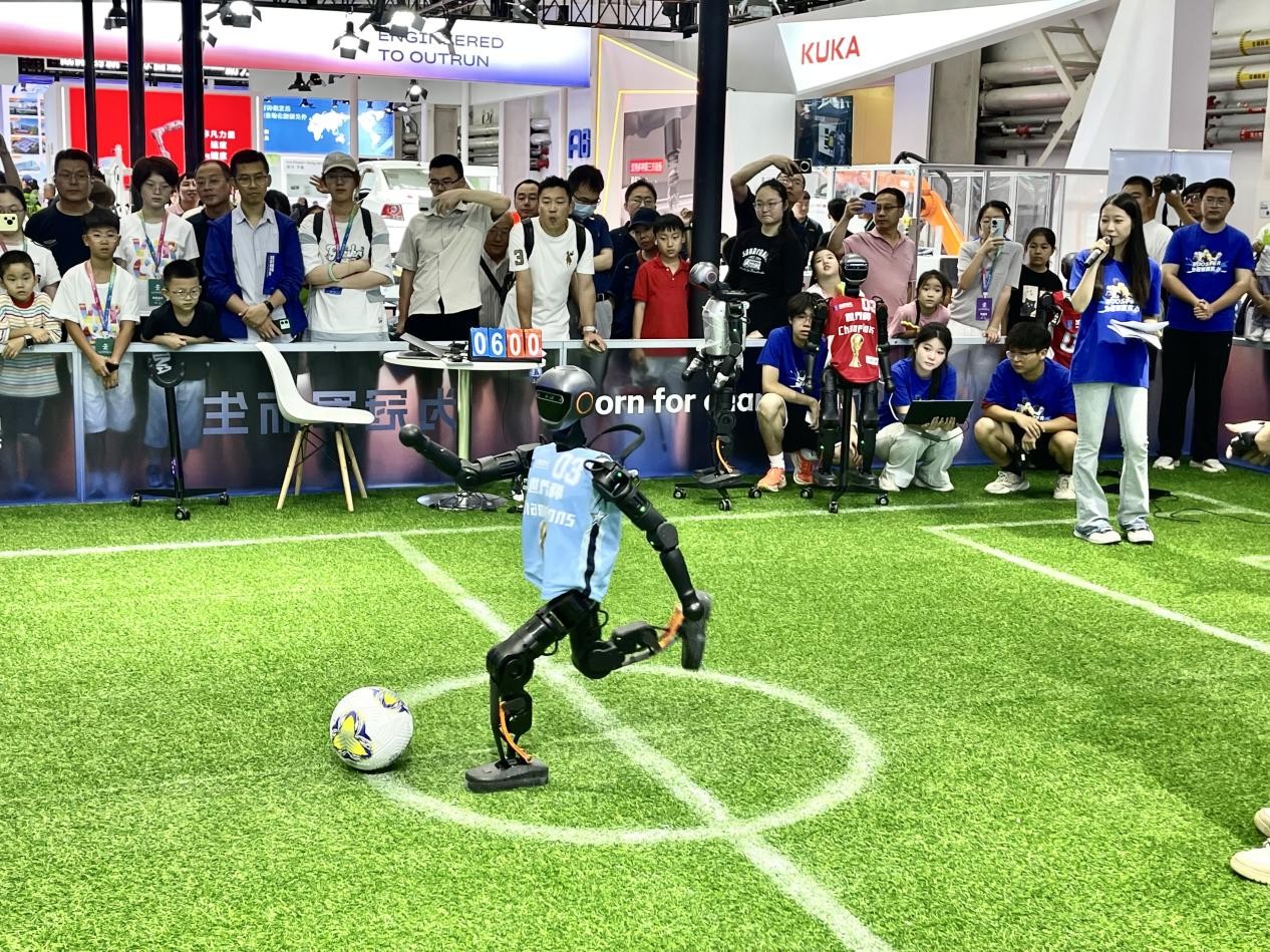 人形機器人在大會現(xiàn)場上演精彩足球?qū)Q。人民網(wǎng)記者 栗翹楚攝