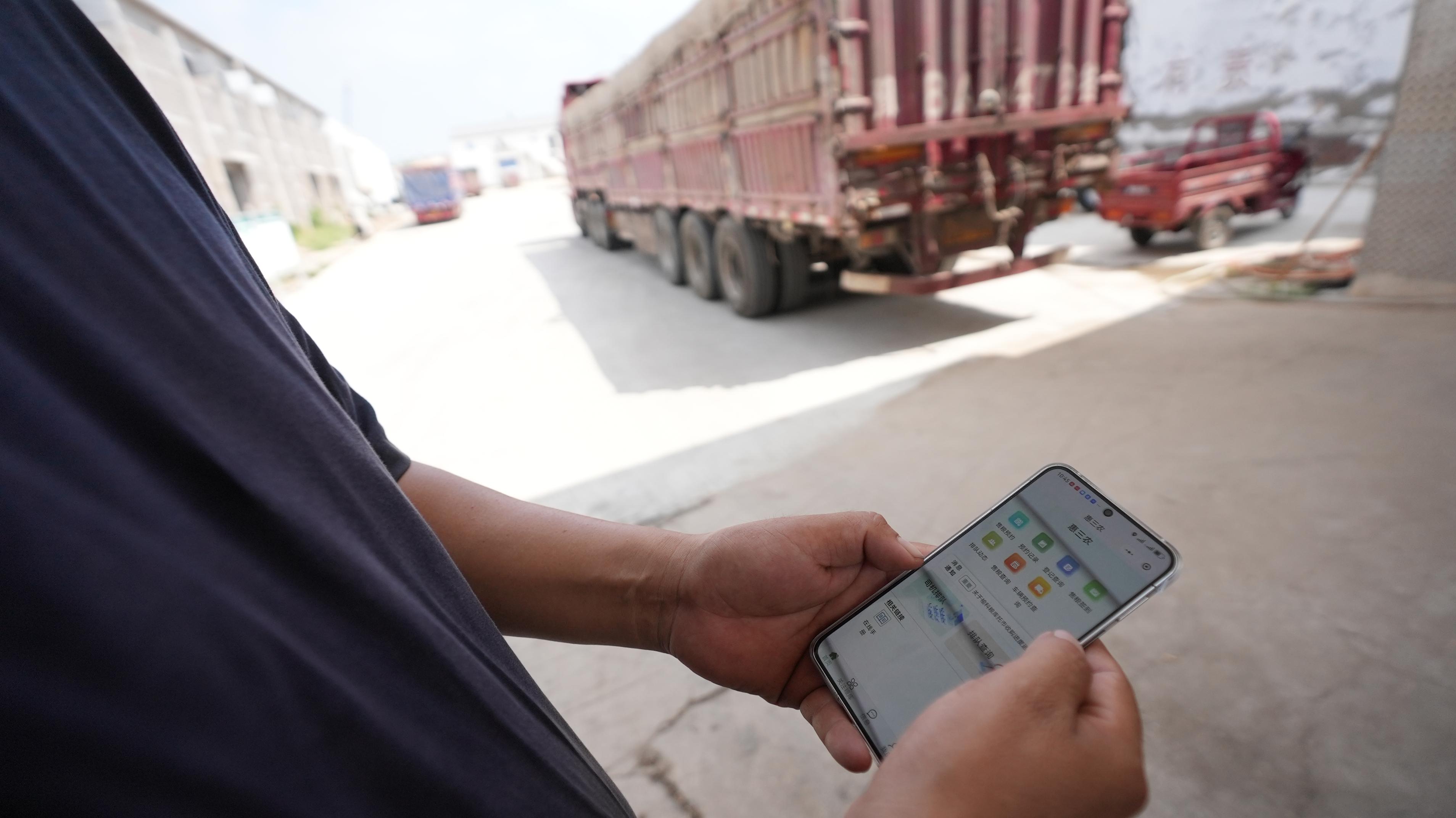 運(yùn)糧司機(jī)向記者展示“惠三農(nóng)“小程序。人民網(wǎng)記者 李棟攝