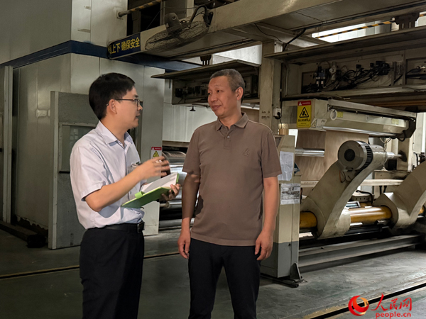 銀行工作人員走訪啟越紙品。人民網(wǎng)記者 杜燕飛攝