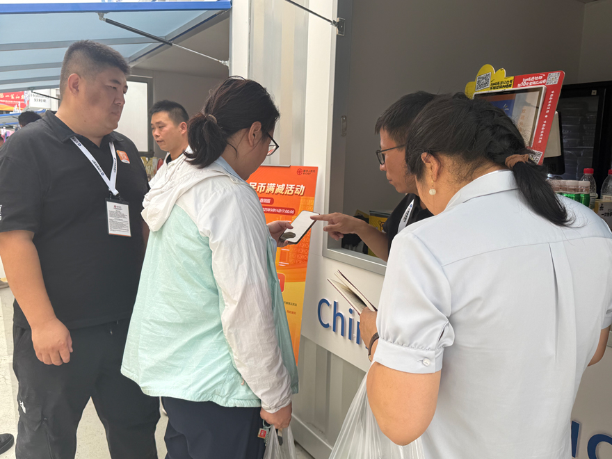 銀行工作人員指導(dǎo)觀眾開(kāi)通數(shù)字人民幣錢(qián)包。人民網(wǎng)記者 杜燕飛攝