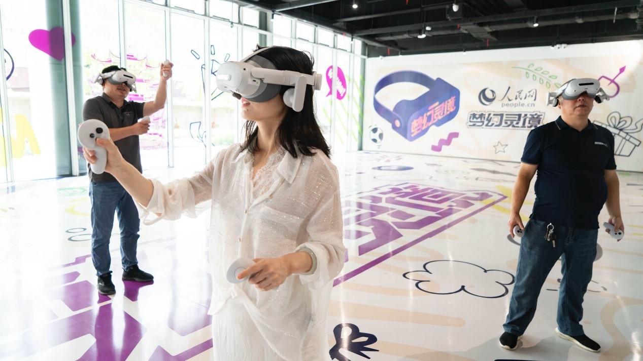 玩家佩戴VR設(shè)備在人民網(wǎng)·夢(mèng)幻靈境AI+XR大空間中體驗(yàn)