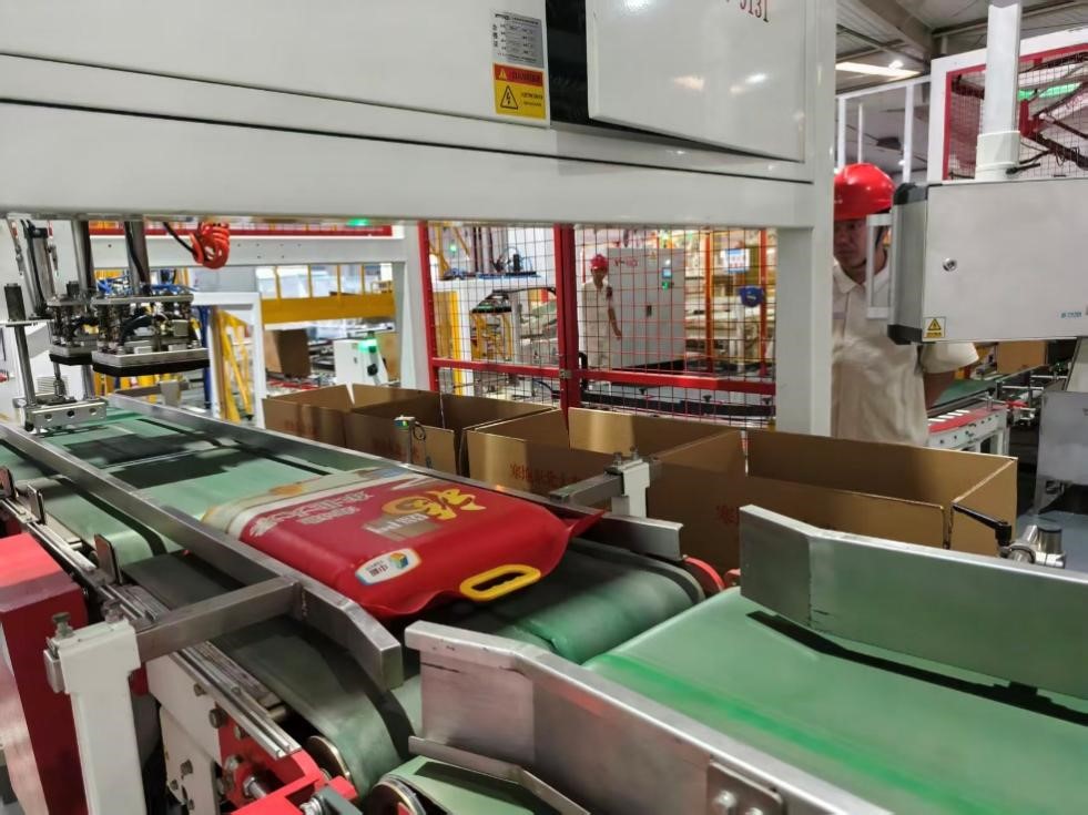 糧食生產(chǎn)線上，一袋袋大米被打包入箱。人民網(wǎng)記者 李棟攝