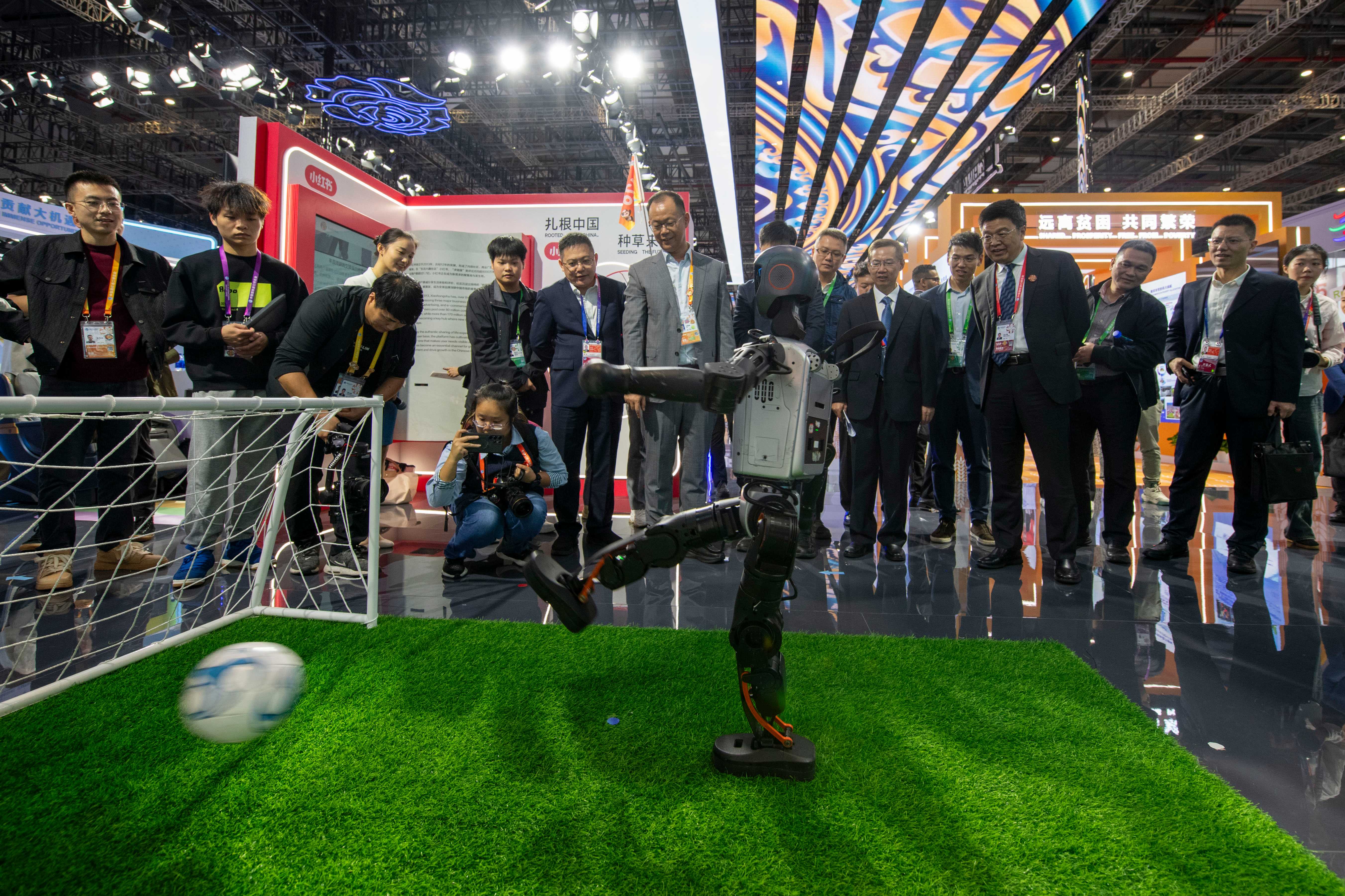 在第八屆進(jìn)博會(huì)中國(guó)館，人形機(jī)器人踢球射門(mén)，吸引不少參觀者駐足。人民網(wǎng)記者 翁奇羽攝