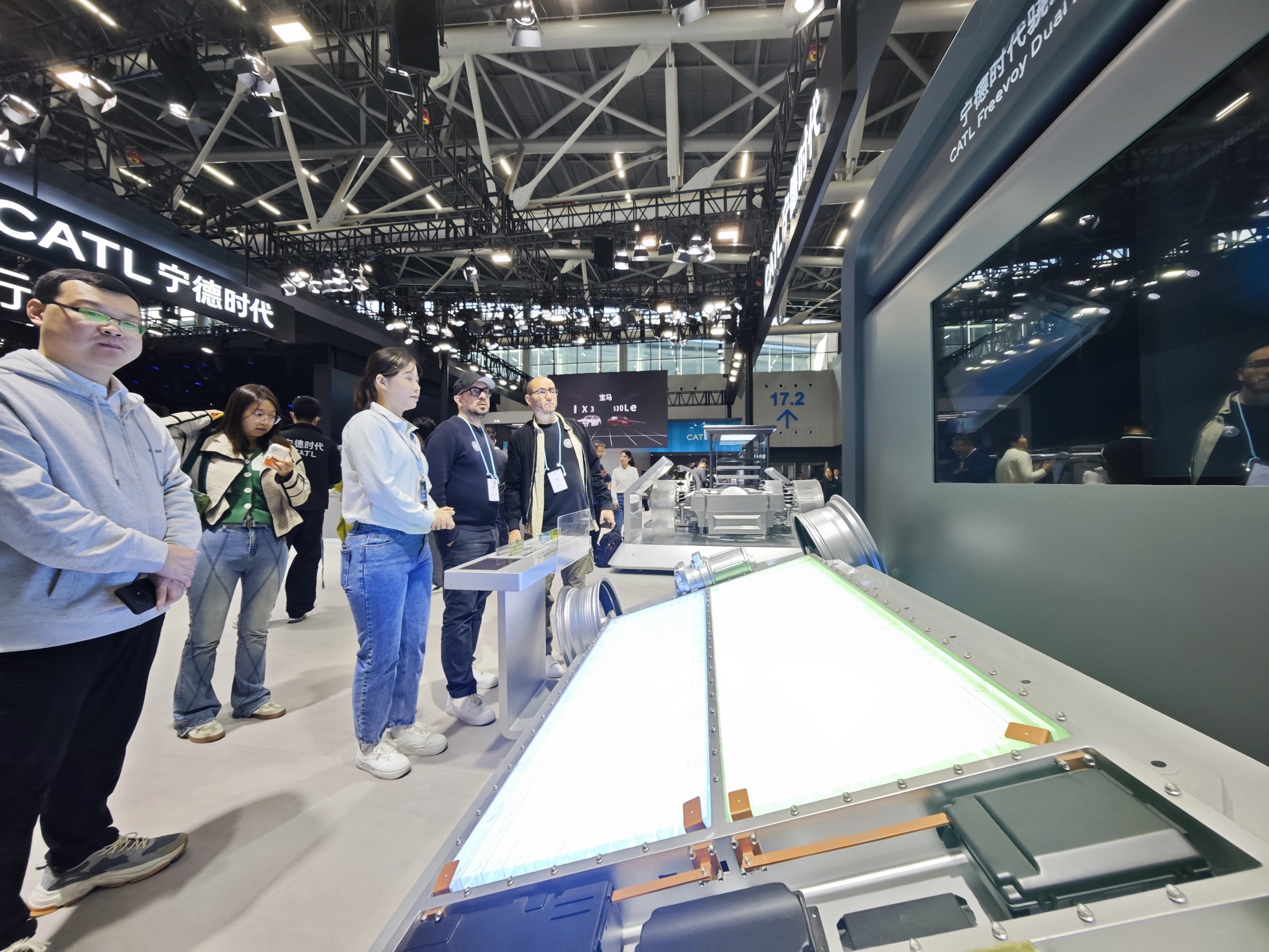 外國(guó)參觀者正在觀看汽車電池技術(shù)演示。 人民網(wǎng)記者 車柯蒙攝