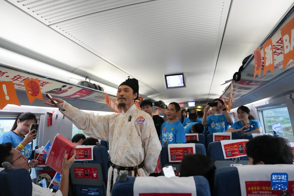 在杭臺高鐵“浙BA”球迷車廂內(nèi),“詩人李白”表演者與球迷旅客互動(9月10日攝)。新華社記者 黃宗治攝