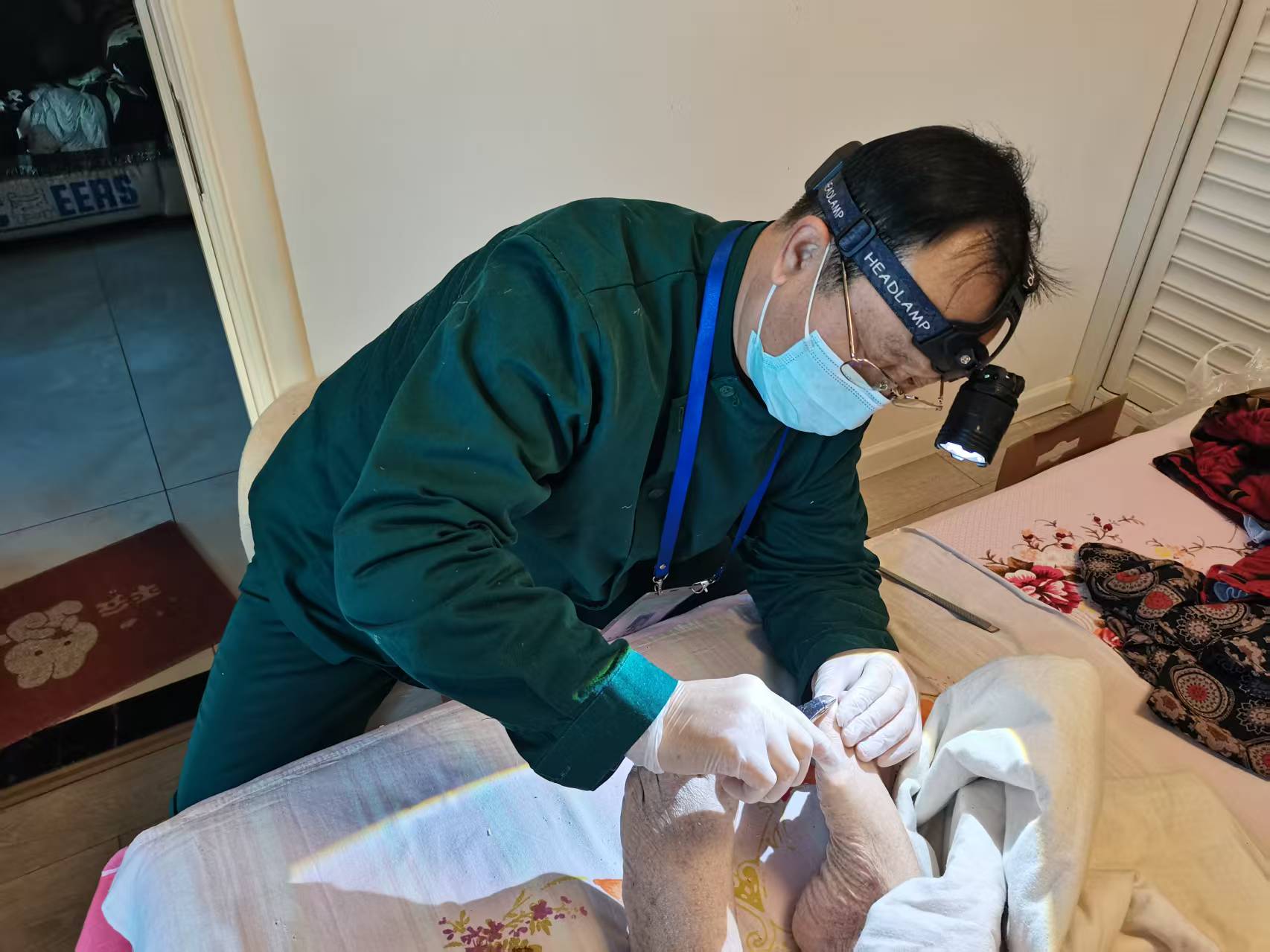 護(hù)理員王新中正在為侯阿姨的老伴提供修腳服務(wù)。受訪者供圖
