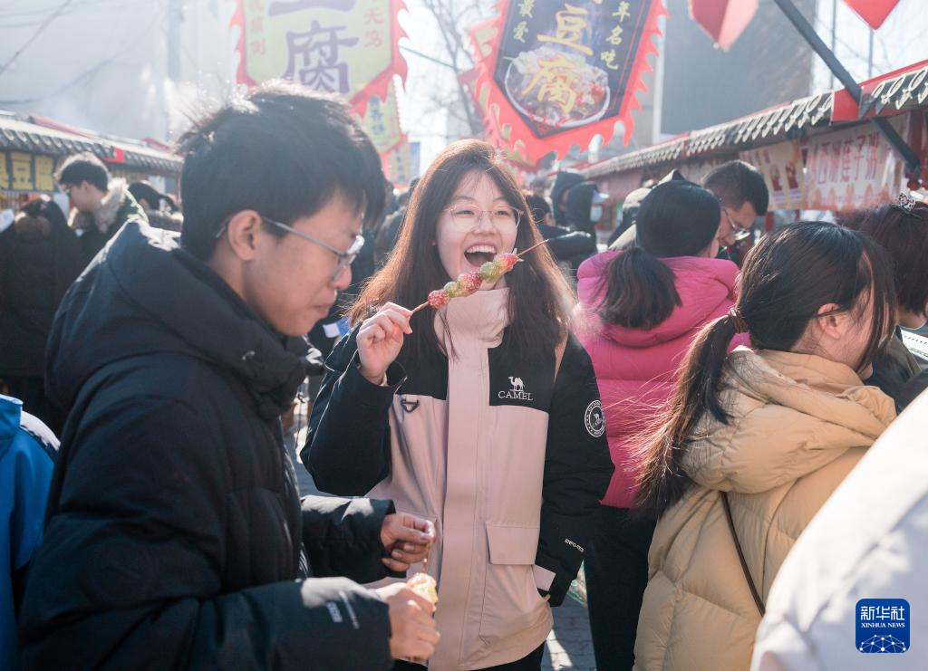 在北京沙河大集，一名女孩在品嘗特色小吃。新華社記者 才揚攝