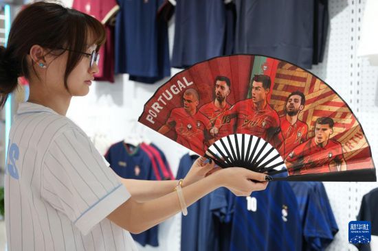 5月15日，義烏國(guó)際商貿(mào)城的商戶展示獲得授權(quán)設(shè)計(jì)生產(chǎn)的葡萄牙國(guó)家足球隊(duì)折扇。